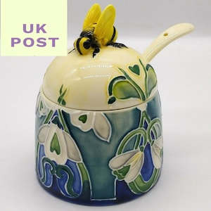 Honey Pot with dipper spoon and bee.  Snowdrop design made with Ceramic pottery and hand painted. Delivered from the UK