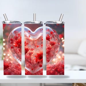 Könnte beinhalten: Drei Edelstahlbecher mit einem roten Herzdesign. Das Herz ist mit roten Blumen gefüllt und hat eine durchscheinende, glasartige Optik. Der Hintergrund ist ein weiches, verschwommenes Rot.