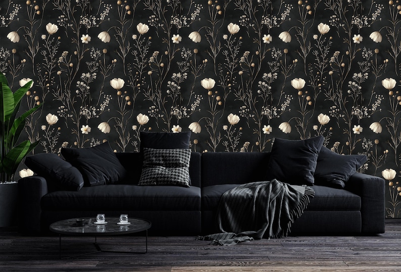 May include: A black couch with black throw pillows and a black and white throw blanket in front of a black and white floral wallpaper.
