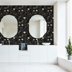 May include: A bathroom with a black and white floral wallpaper, a white double vanity with two sinks, two round mirrors, and a small potted tree in the corner.