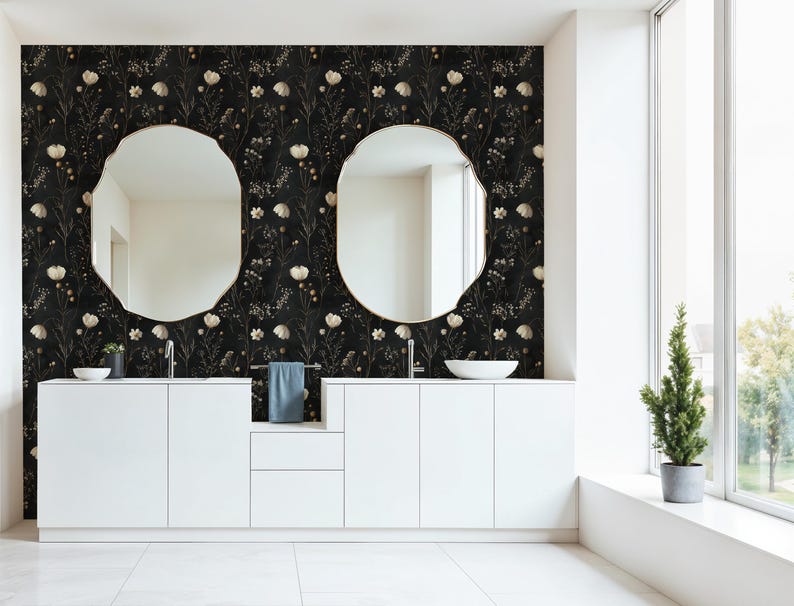 May include: A bathroom with a black and white floral wallpaper, a white double vanity with two sinks, two round mirrors, and a small potted tree in the corner.