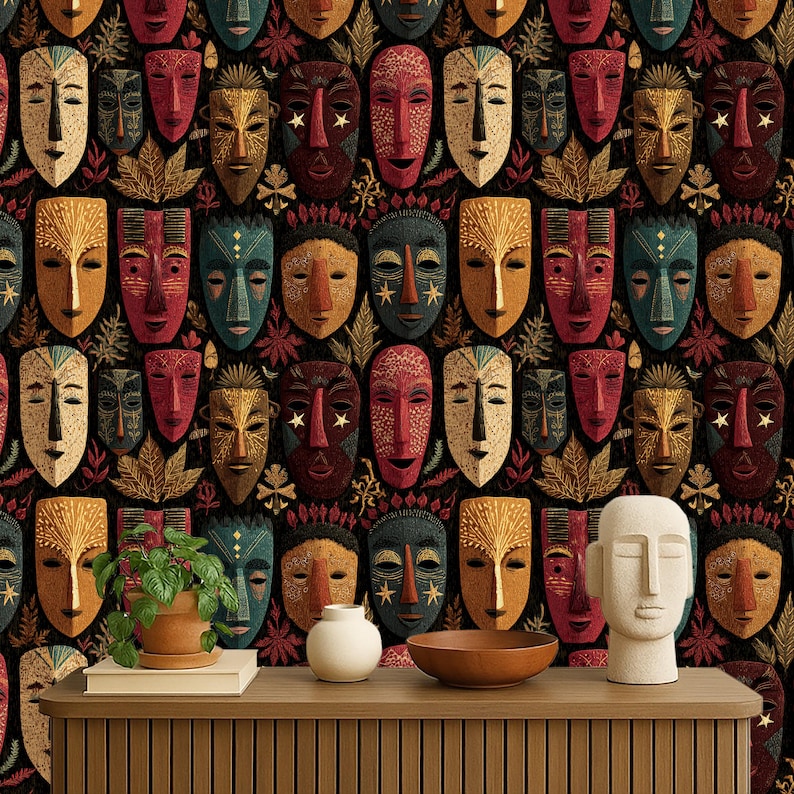 May include: A repeating pattern of colorful tribal masks in shades of red, gold, blue, and brown against a black background. The masks have various designs and are interspersed with leaf and floral motifs. A wooden console table displays a plant, a white vase, and a wooden bowl.