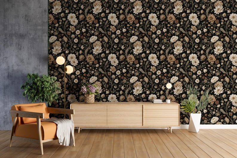 May include: A room interior featuring a floral wallpaper in black, beige, and brown tones. A wooden cabinet, an orange armchair, and a floor lamp are in front of the wallpaper. The room has a wooden floor and a gray wall.
