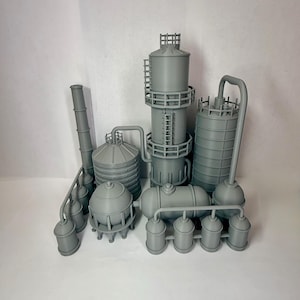 May include: A gray industrial model featuring various structures, including cylindrical tanks, a tall tower with a ladder, and interconnected pipes. The model is a detailed representation of a factory or processing plant.
