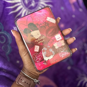 May include: A clear phone case with a pink and red design. The case features illustrations of a couple, roses, hearts, and the phrases "You are my life" and "my favorite person".