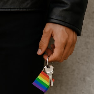 プライドキーチェーンのストックフォト – 男性の手とレザージャケット | LGBTQ、ソーシャルメディア用フラットレイ | JPG ダウンロード