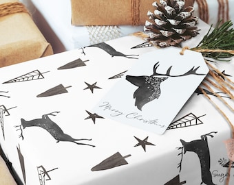 May include: White gift wrap with a black and white pattern of deer, trees, and stars. The gift wrap is tied with twine and has a gift tag that says "Merry Christmas".