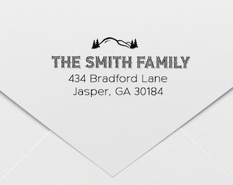May include: Black and white return address stamp with a mountain range and pine trees design. The text reads "THE SMITH FAMILY 434 Bradford Lane Jasper, GA 30184".