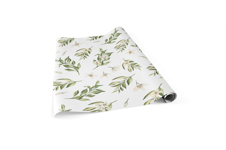 May include: White wrapping paper with a repeating pattern of green leaves and white flowers.