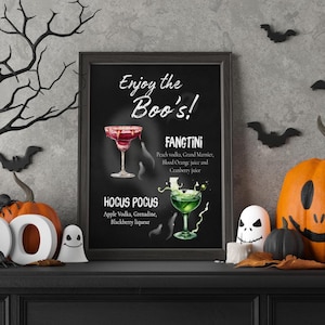 Könnte beinhalten: Ein gerahmtes schwarzes Kreidetafel-Schild mit dem weißen Text Enjoy the Boo's, das Illustrationen eines roten Fangtini-Cocktails und eines grünen Hocus Pocus-Cocktails sowie deren Zutatenlisten in weißer Schrift auf dem dunklen Hintergrund zeigt.