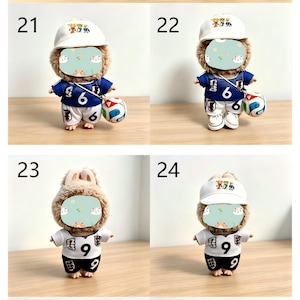 May include: A series of small plush dolls, each wearing a soccer uniform and a baseball cap. The dolls have a furry head and are holding a soccer ball. The uniforms are either blue or white, with the number 6 or 9 on the front.