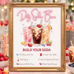 May include: A gold-framed sign titled Dirty Soda Bar featuring illustrations of three iced drinks with fruit garnishes. The text reads Build Your Soda with instructions to fill with ice, choose soda, add syrup, add cream, garnish with fruit, mix, sip, and enjoy.