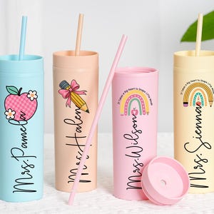 May include: Four colorful tumblers with straws, each featuring a teacher-themed design. The tumblers are light blue, peach, pink, and yellow, with illustrations of an apple, pencil, and rainbow. Each tumbler has a teacher's name.