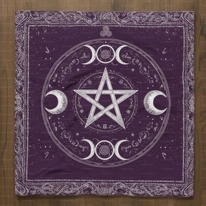 Op de afbeelding: Een vierkant, paars wandtapijt met een witte pentagram, maanstanden en andere hemelse symbolen. Het ontwerp is omlijst door een sierlijke rand. Het wandtapijt wordt waarschijnlijk gebruikt voor spirituele of decoratieve doeleinden.