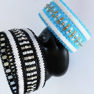 Op de afbeelding: Twee kralenarmbanden, een zwart-wit met zilveren accenten en een blauw-wit met gouden accenten.