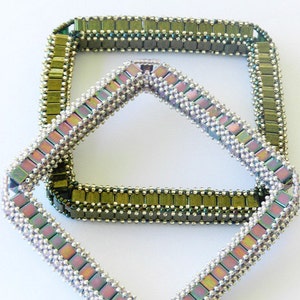 May include: Two square-shaped beaded bracelets, one is a light green and silver color, and the other is a light purple and silver color. The bracelets are stacked on top of each other.