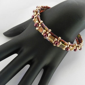 May include: A multi-strand bracelet with brown, gold, and iridescent beads. The bracelet is made with small square beads and round beads.