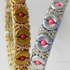 K&ouml;nnte beinhalten: Zwei Perlenarmb&auml;nder mit silbernen und goldenen Akzenten. Ein Armband hat rote Perlen und das andere hat rosa Perlen.