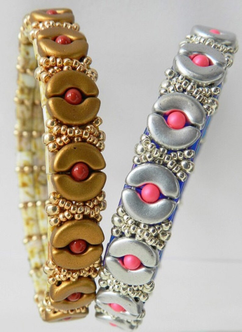 K&ouml;nnte beinhalten: Zwei Perlenarmb&auml;nder mit silbernen und goldenen Akzenten. Ein Armband hat rote Perlen und das andere hat rosa Perlen.