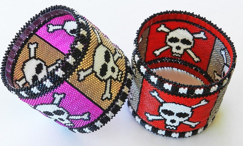 Puede incluir: Dos pulseras de cuentas con un dise&ntilde;o de calavera y huesos cruzados. Una pulsera es roja, blanca y negra, y la otra es rosa, dorada y negra.