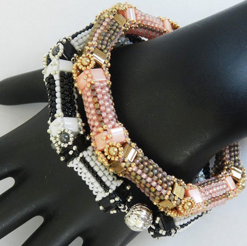 Peut inclure: Trois bracelets en perles empil&eacute;s sur une main de mannequin. Le bracelet du haut est rose et marron avec des accents dor&eacute;s. Le bracelet du milieu est noir et blanc avec des accents argent&eacute;s. Le bracelet du bas est noir et blanc avec une perle argent&eacute;e.