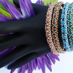 May include: Four beaded bracelets in shades of pink, brown, blue, and green. The bracelets are stacked on a black mannequin hand.