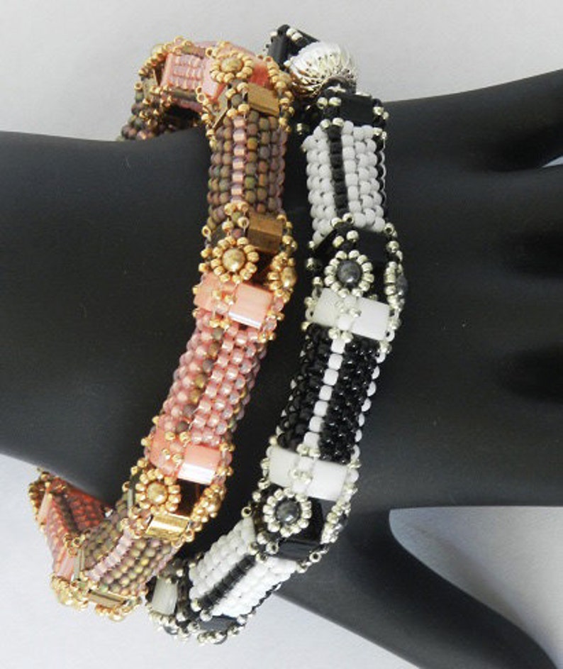 Peut inclure: Deux bracelets en perles, l'un avec des perles noires et blanches et l'autre avec des perles roses, brunes et dor&eacute;es.