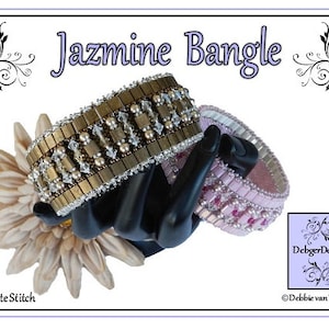 May include: Two beaded bracelets, one in gold and silver tones and one in pink and white, are displayed on a hand. The bracelets are made with peyote stitch and are labeled "Jazmine Bangle" and "Debber Designs".