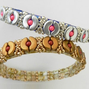 K&ouml;nnte beinhalten: Zwei Perlenarmb&auml;nder mit silberner und goldener Oberfl&auml;che. Die Armb&auml;nder zeigen ein sich wiederholendes Muster aus halbmondf&ouml;rmigen Perlen mit rosa und roten Akzenten.