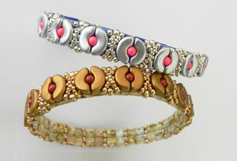 K&ouml;nnte beinhalten: Zwei Perlenarmb&auml;nder mit silberner und goldener Oberfl&auml;che. Die Armb&auml;nder zeigen ein sich wiederholendes Muster aus halbmondf&ouml;rmigen Perlen mit rosa und roten Akzenten.