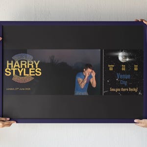 May include: A framed poster with a dark blue border. The poster features the text "HARRY STYLES" in gold and a photo of a person. A ticket design is on the right with the text "Venue City" and "See you there Becky!"