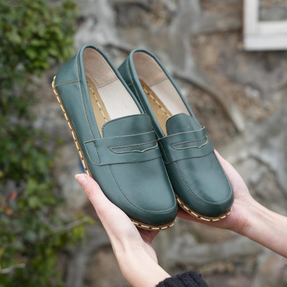 Larges sandales pieds nus en cuir cuivre mis à la terre