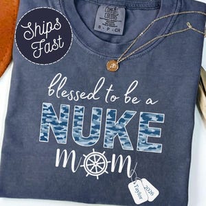 May include: A set of three ceramic mugs with a speckled, matte finish. The mugs are in shades of cream, light gray, and dark gray. Each mug has a simple, minimalist design and a rounded handle.