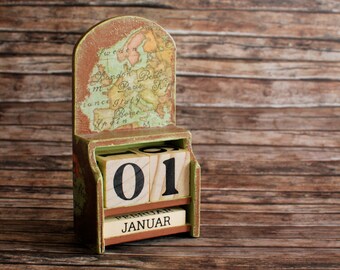 Perpetual wooden calendar with day cubes and months in a caddy box and map of OLD and NEW world