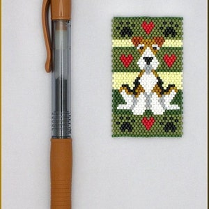 May include: A green, yellow, red, black and white beaded bookmark featuring a dog design. The bookmark is approximately the size of a pen.
