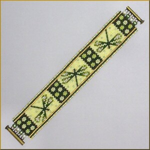 Puede incluir: Una pulsera de cuentas con un diseño de libélula. La pulsera es principalmente verde claro con detalles en verde oscuro y dorado. Los diseños de libélulas y flores están hechos con pequeñas cuentas. La pulsera tiene un cierre con pequeñas cuentas perladas.