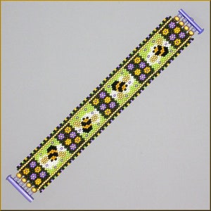 Op de afbeelding: Een groene, gele, zwarte en paarse kralenarmband met een bijenontwerp. De armband heeft aan beide uiteinden een sluiting.