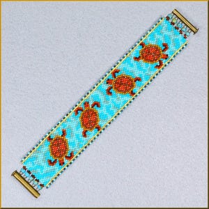 May include: A beaded bracelet with a turquoise zigzag pattern and four orange and red turtle designs. The edges are lined with gold and small blue beads, with gold clasps. The bracelet is approximately 18 cm long.
