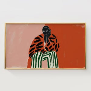 May include: An abstract art print featuring a seated figure in a patterned jacket and striped pants. The figure is set against a backdrop of coral and peach hues, framed in a gold border. The artwork has a modern, minimalist style.