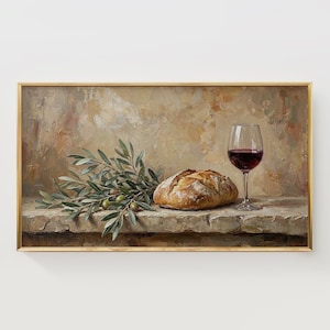 Puede incluir: Pintura enmarcada de naturaleza muerta con una hogaza de pan, una copa de vino tinto y ramas de olivo. La pintura tiene una paleta de colores cálidos, un fondo texturizado y un marco dorado.