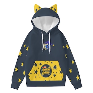 以下が含まれることがあります： 黄色い星のアクセントと猫耳フードが付いたネイビーブルーのパーカー。「Superstar Daycare」の文字と漫画の月のグラフィックが入った黄色のカンガルーポケットが特徴です。白いドローストリング。