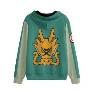 Puede incluir: Una sudadera con capucha verde con un gran diseño de dragón amarillo en la espalda. Las mangas tienen una franja verde claro en el lateral. Un pequeño parche con un diseño rojo y blanco está en la manga derecha.
