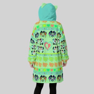 May include: A light green hooded sweatshirt with a cat ear design on the hood. The sweatshirt features a repeating pattern of cartoon characters, hearts, and stars in various colors. The sleeves are long, and the garment is knee-length.