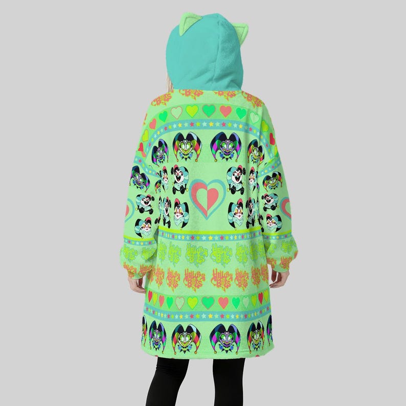 May include: A light green hooded sweatshirt with a cat ear design on the hood. The sweatshirt features a repeating pattern of cartoon characters, hearts, and stars in various colors. The sleeves are long, and the garment is knee-length.