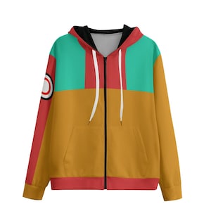 Puede incluir: Una sudadera con cremallera y diseño de bloques de color. La sección superior es turquesa, con una franja roja en las mangas y una banda roja en la parte inferior. El cuerpo principal es amarillo mostaza, con una cremallera blanca y un gráfico circular en la manga izquierda.