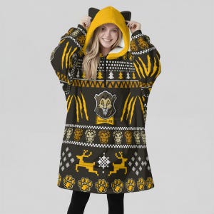 May include: A black and yellow hooded blanket with a Savaraclaw design. The blanket features a yellow hood with black ears, a zipper, and a pattern of yellow claw marks, lion faces, and paw prints. The text "Savaraclaw" is visible.