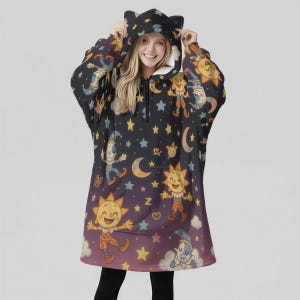 Pode incluir: Um cobertor com capuz preto com um design celestial caprichoso com sóis sorridentes, luas, estrelas e personagens brincalhões. O cobertor tem um bolso frontal e um capuz com orelhas de gato. O interior é forrado com lã polar branca.