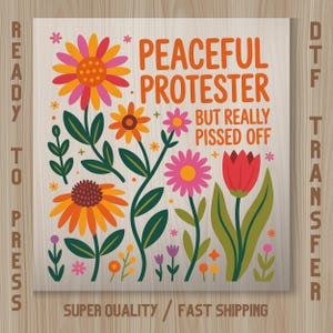 May include: A colorful floral design with the text "PEACEFUL PROTESTER BUT REALLY PISSED OFF" on a wooden background. The design includes various flowers in shades of orange, pink, and red, with green leaves and stems. Ready to press DTF transfer.