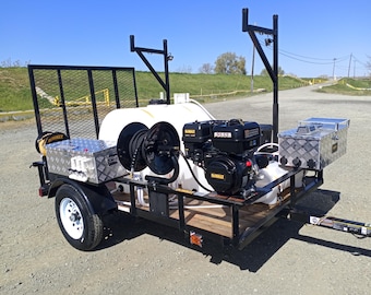 May include: A white trailer with a black metal frame and a black engine. The trailer has a white water tank, two black hose reels, and two silver toolboxes. The trailer is on a gravel surface.