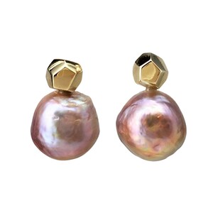 May include: A pair of earrings featuring a large, iridescent pink pearl with a gold geometric accent.